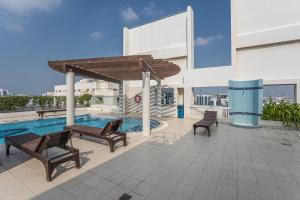 HiGuests - Cheerful Apt With Stunning Views in Port Saeed في دبي: فناء على كراسي ومسبح في مبنى