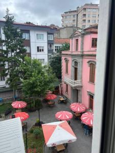 a group of tables with red umbrellas in a city at Trabzon Meydan Şehir Merkezi Trabzon City Centre in Trabzon