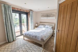 a bedroom with a bed and a large window at Gaer Fawr Barns in Guilsfield