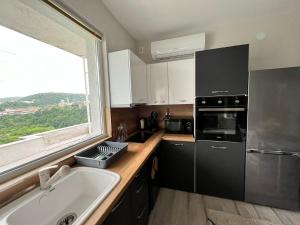 eine Küche mit einem Waschbecken und einem großen Fenster in der Unterkunft Apartment Enina in Weliko Tarnowo