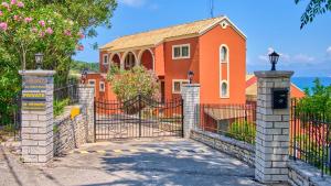 une maison orange avec une porte devant dans l'établissement Chrismos Luxury Suites Apraos Corfu, à Apraos