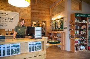 a woman standing at a pharmacy counter in a store at Huttopia Etang Fouché in Arnay-le-Duc +15 photos