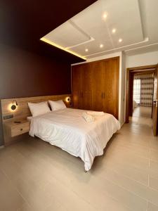 una camera da letto con un grande letto con lenzuola bianche di Appartement moderne au décor raffiné a Kenitra