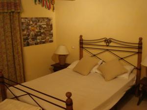 una camera da letto con un grande letto con lenzuola e cuscini bianchi di La Monella a Carpaneto Piacentino