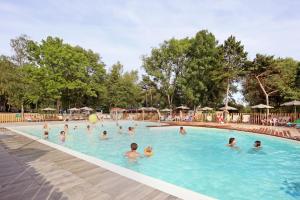 a group of people swimming in a swimming pool at Huttopia Etang Fouché in Arnay-le-Duc