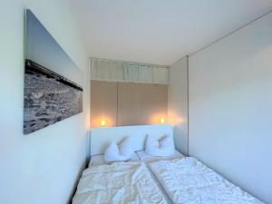 a small bedroom with a bed with two pillows at Panoramic App A03-1 in Sierksdorf +22 photos