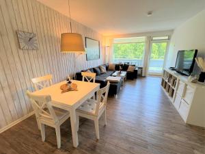 a living room with a table and a couch at Panoramic App A03-1 in Sierksdorf