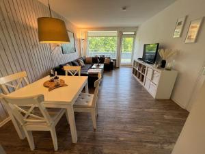 a living room with a table and a couch at Panoramic App A03-1 in Sierksdorf