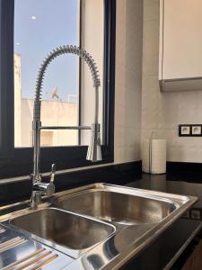 a stainless steel sink in a kitchen with a window at Appartement moderne au décor raffiné in Kenitra +47 photos