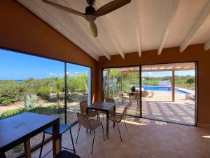 a living room with tables and chairs and a patio at Punta Rasa Formentera Apartments in Cala Saona