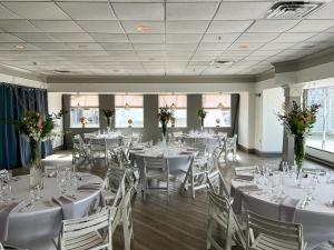 een feestzaal met witte tafels en stoelen bij The Newport Harbor Hotel & Marina in Newport