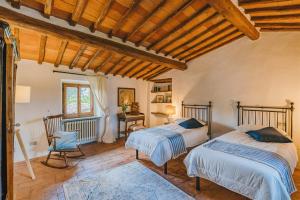 a bedroom with two beds and a wooden ceiling at Podere Lupinati in Panzano