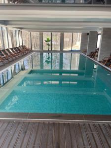 a large swimming pool in a building with chairs at Milmari in Kopaonik
