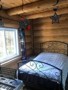 - une chambre avec un lit dans une cabane en rondins dans l'établissement Le relaxant chalet du petit ruisseau, à Mandeville