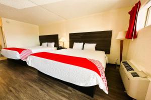 Habitación de hotel con 2 camas con sábanas rojas y blancas en Oyo Hotel San Antonio Lackland AFB Seaworld Hwy 90 W en San Antonio