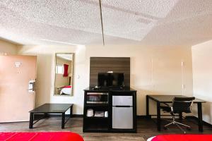Habitación con cama, escritorio y TV. en Oyo Hotel San Antonio Lackland AFB Seaworld Hwy 90 W en San Antonio