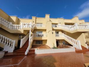 a large building with stairs and a blue sky at Apartament CALETA in Caleta De Fuste