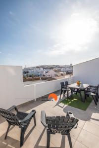 a patio with chairs and a table on a roof at #074 Casa dos Arcos by Home Holidays in Albufeira