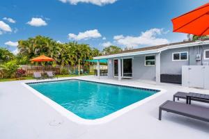 a swimming pool in the backyard of a house at Spacious 5 Bedrooms with Large Pool, 12 minutes to the Ocean in Fort Lauderdale