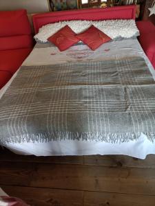 łóżko z czerwonym zagłówkiem i czerwonymi poduszkami w obiekcie Maison du Mont w Aoście