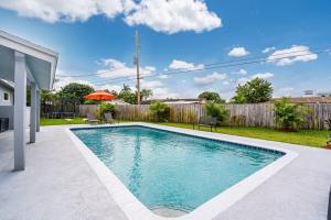 a swimming pool in the backyard of a house at Spacious 5 Bedrooms with Large Pool, 12 minutes to the Ocean in Fort Lauderdale