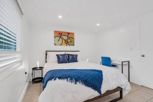 a bedroom with a bed and a blue chair at Spacious 5 Bedrooms with Large Pool, 12 minutes to the Ocean in Fort Lauderdale