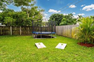 a playground in a yard with a trampoline at Spacious 5 Bedrooms with Large Pool, 12 minutes to the Ocean in Fort Lauderdale