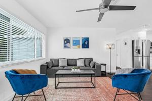 a living room with a couch and a table and blue chairs at Spacious 5 Bedrooms with Large Pool, 12 minutes to the Ocean in Fort Lauderdale