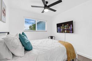 a bedroom with a bed with a ceiling fan at Spacious 5 Bedrooms with Large Pool, 12 minutes to the Ocean in Fort Lauderdale