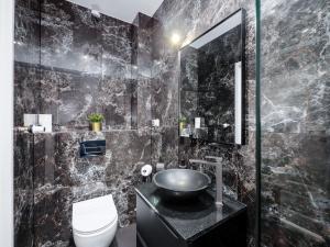 czarna łazienka z umywalką i toaletą w obiekcie PORT 77 w mieście Krynica Morska