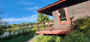 a house with a deck next to a body of water at Hotel y Cabañas Las Mellizas - Caja Los Andes in Los Ángeles