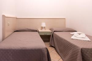 Zimmer mit 2 Betten und einem Tisch mit einer Lampe in der Unterkunft Residence Rialto in Triest