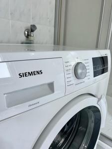 a white washing machine sitting in front of a mirror at Moderne Ferienwohnung nahe Zentrum Waidhofen/Ybbs in Waidhofen an der Ybbs