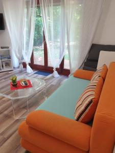 Ferienwohnung 3 - Gourmetzimmer في Bestensee: غرفة معيشة مع أريكة برتقالية وطاولة