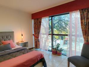 een slaapkamer met een bed en een groot raam bij MENDOZA Suites 8 in Mendoza