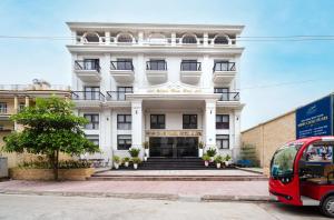 a red bus parked in front of a building at Minh Chau Pearl Hotel & Spa - Quan Lan Island in Quang Ninh