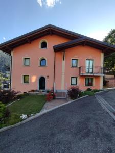 una casa grande de color naranja con entrada en Appartamenti Flora Alpina en Temù
