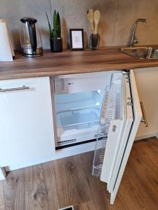 a refrigerator with its door open in a kitchen at Beautiful studio 14F in chic neighborhood in center in Rotterdam