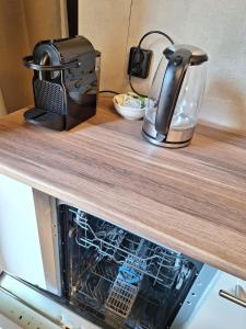 a kitchen counter top with a tea kettle and a dishwasher at Beautiful studio 14F in chic neighborhood in center in Rotterdam