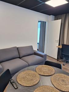 een woonkamer met een bank en twee ronde tafels bij Beautiful studio 14F in chic neighborhood in center in Rotterdam