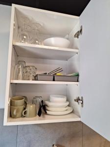 a cupboard with plates and other dishes in it at Beautiful studio 14F in chic neighborhood in center in Rotterdam