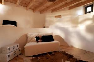 a bedroom with a bed and a white wall at O Moinho 98 - A cozy getaway by the coast in Lourinhã
