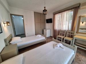 Una habitación de hotel con dos camas y un espejo. en Apartments by Evita's Resort, en Poros