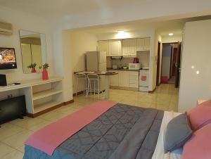 1 dormitorio con 1 cama grande y cocina en MENDOZA Suites 8 en Mendoza