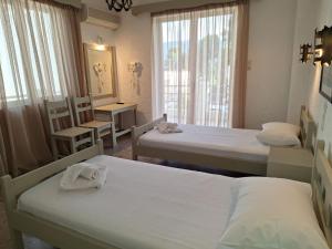 una habitación con dos camas y una mesa y sillas en Apartments by Evita's Resort, en Poros