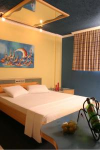1 dormitorio con 1 cama con una pintura en la pared en Motel Kalipso en São José