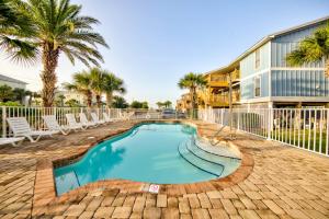 a swimming pool at a resort with palm trees at Sea Horse 112 by Vacation Homes Collection in Gulf Shores