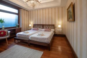 a bedroom with a bed and a chandelier at Casa señorial a 5 minutos del centro in San Sebastián