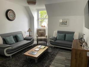 a living room with two couches and a coffee table at The Holiday Hoose in Kinghorn