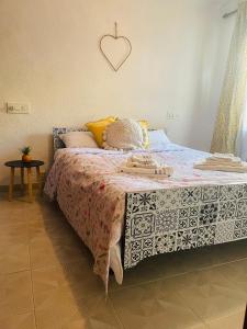 1 dormitorio con 1 cama con un corazón en la pared en Cozy 2-Bedroom Serviced Apartment with Netflix en Puerto de Sagunto